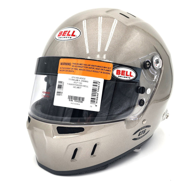 Close-up of Bell GT6 RD 4C EC helmet in titanium finish with barcode label and SNELL/FIA certifications